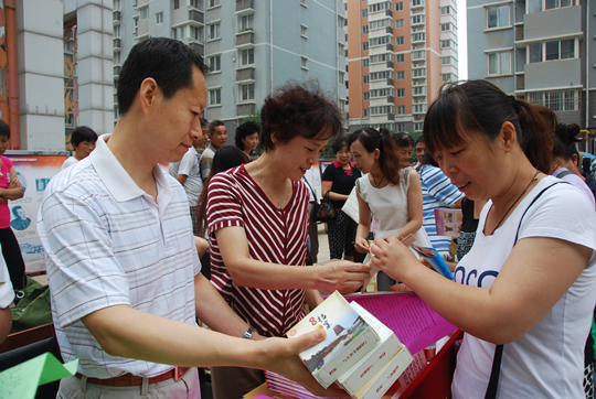 西安市档案局副局长黄海绒（左二）、未央区档案局局长王海鸿（左一）向社区群众发放档案法制宣传材料