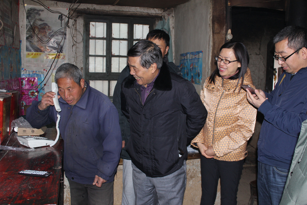 省通管局通信发展处处长王艳芳（左三）、市档案局纪检组组长马大社（左二），在村民董满堂（左一）家中，检查验收有线通话和IPTV开通
